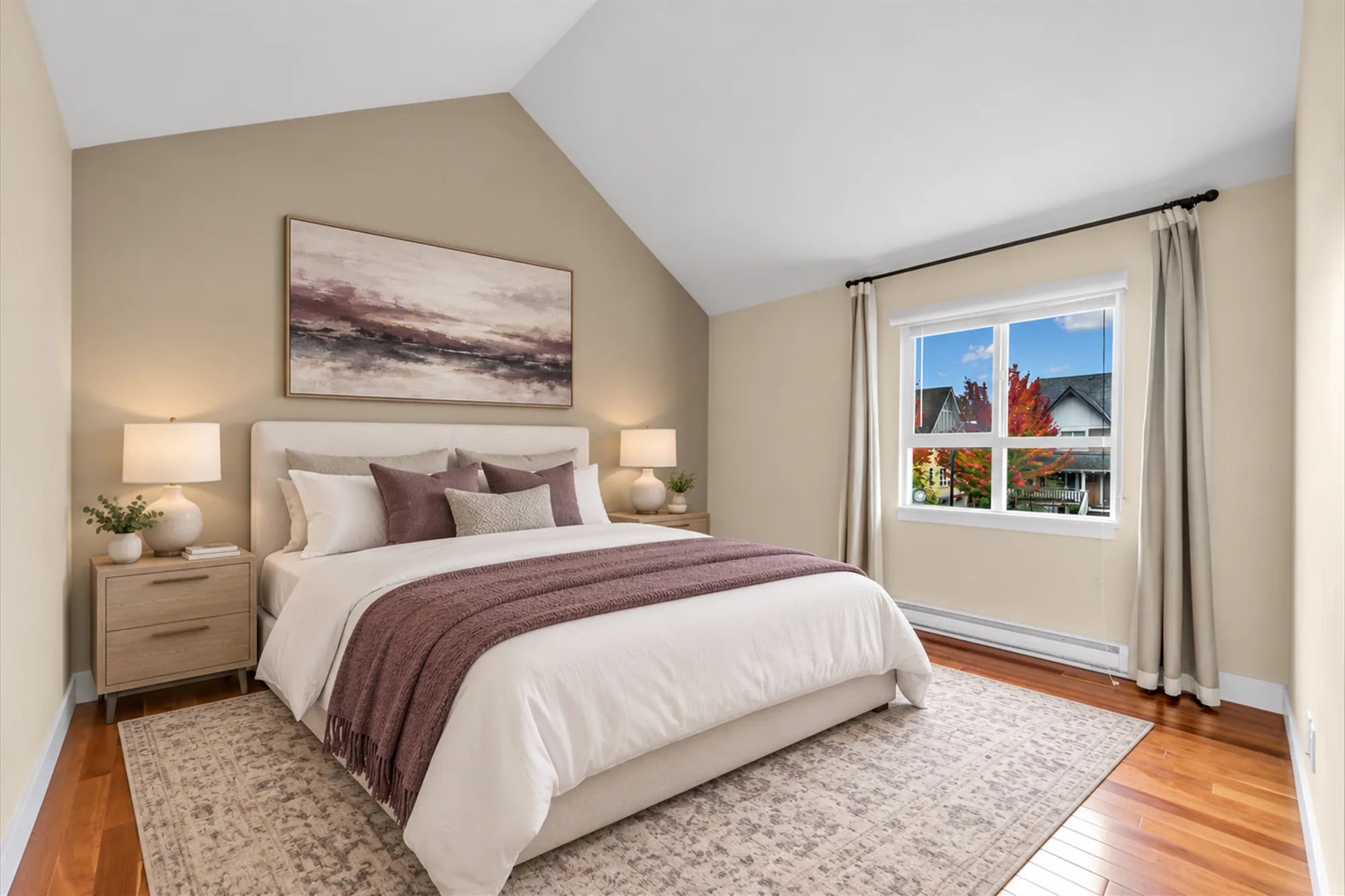 The same frame virtually staged: an upholstered bed with a plum throw, two night tables with lamps, a patterned rug, an abstract print