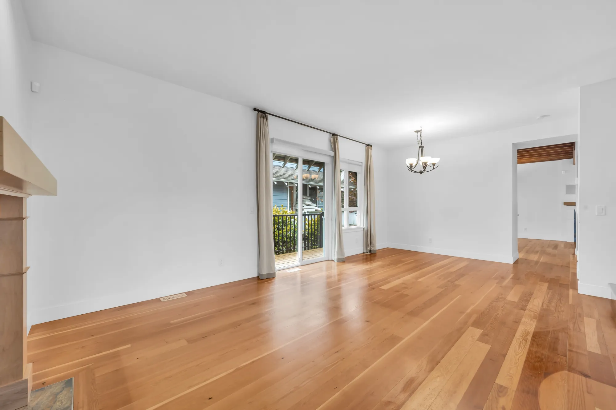 From beside the stair toward the dining room&rsquo;s sliding doors, the chandelier and the doorway to the kitchen
