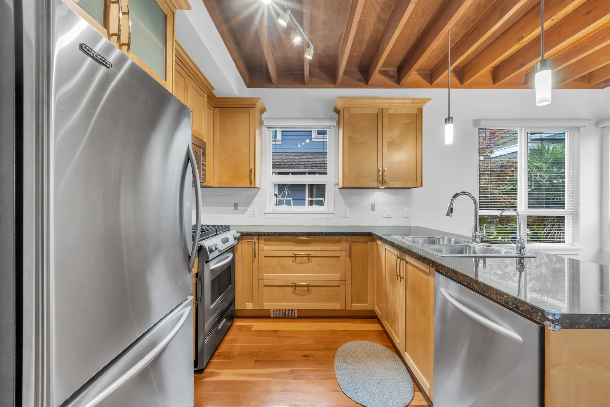 The stainless refrigerator and range, maple cabinets, a double sink under the side window