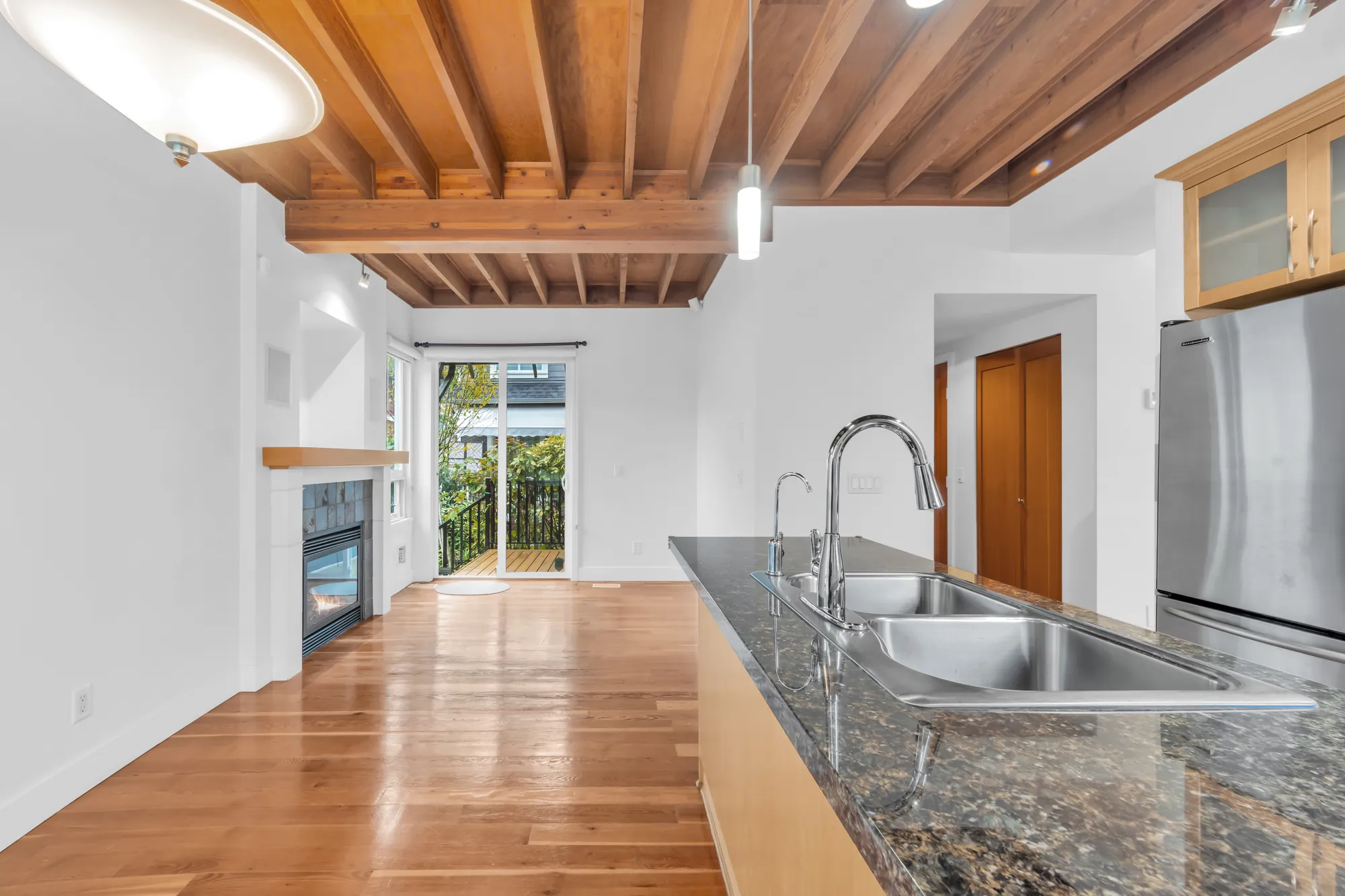 Along the peninsula toward the family room&rsquo;s fireplace and the sliding door to the back deck, the refrigerator at the right