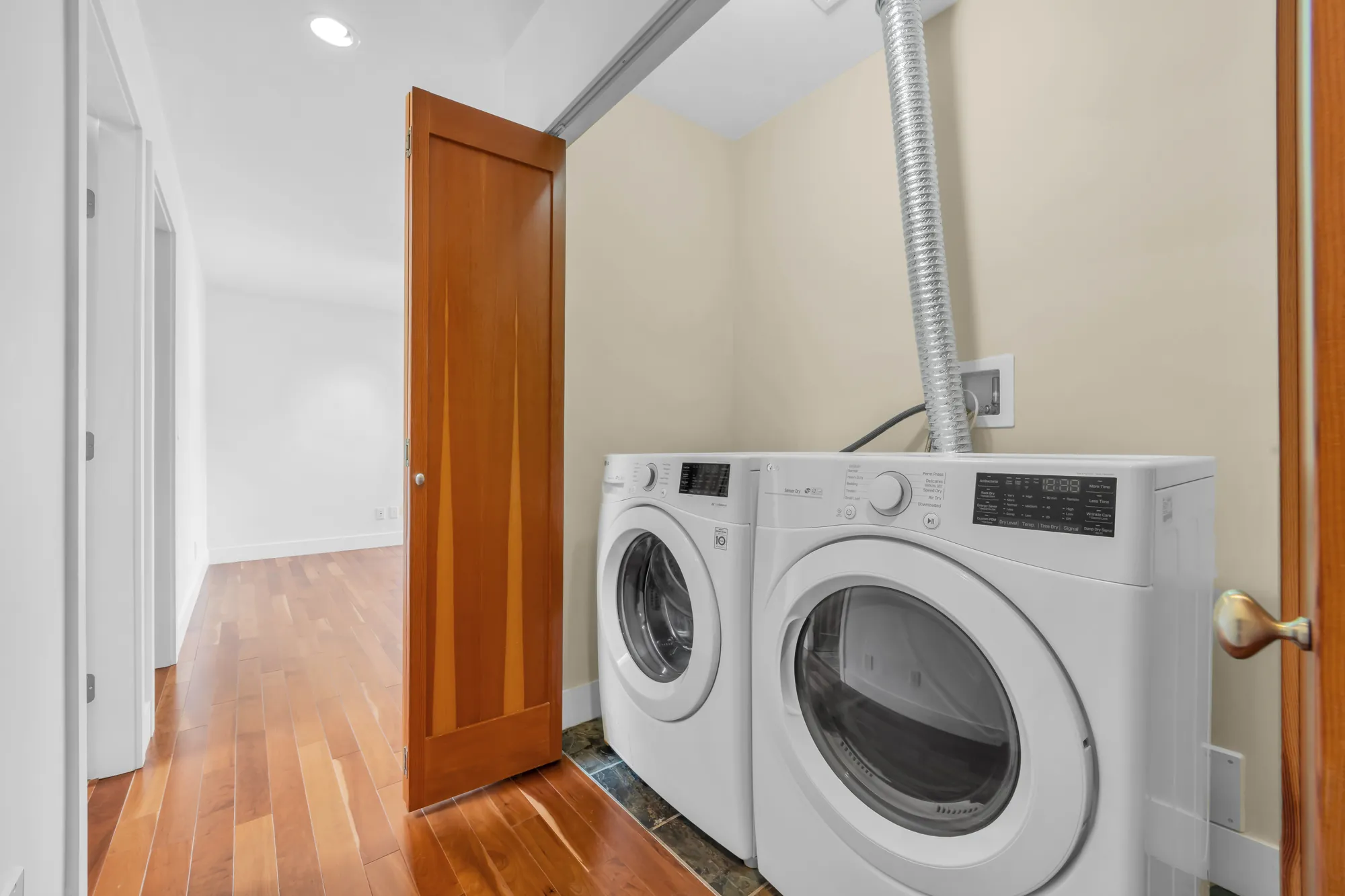 The laundry: a front-loading washer and dryer behind a wood door off the hall