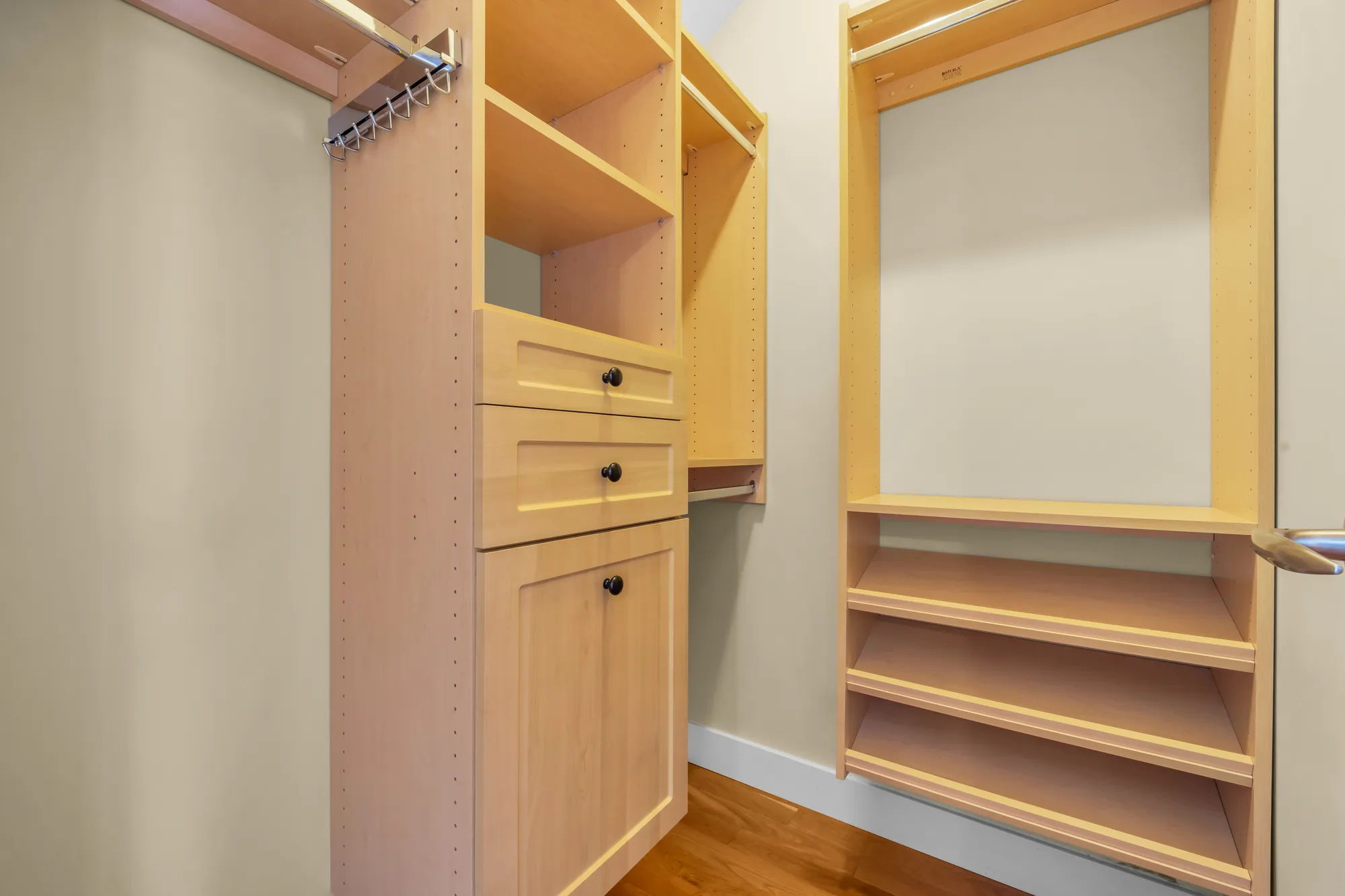 A walk-in closet fitted with maple shelves, drawers and rails